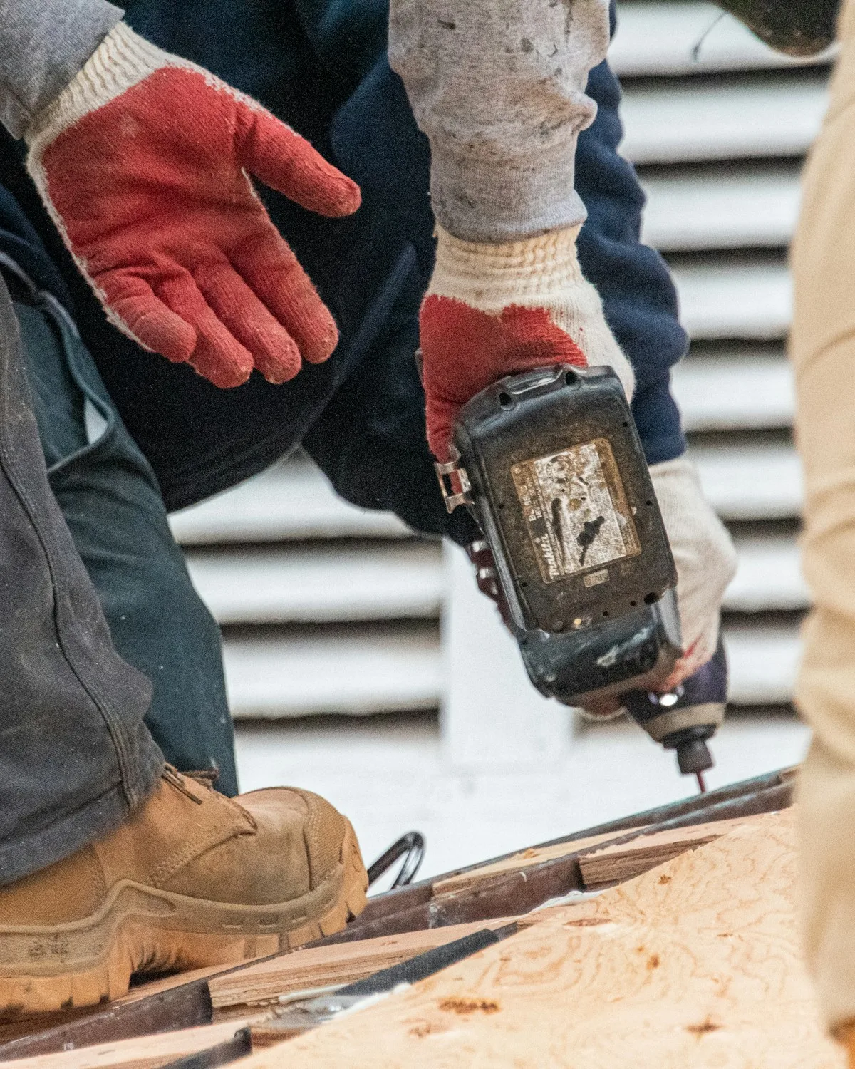Tradesman holding a clipboard reading 'Measure twice, cut once.'
